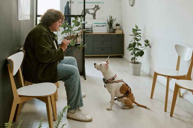 Klinik bekleme salonunda köpeğiyle sırasını bekleyen hasta sahibi